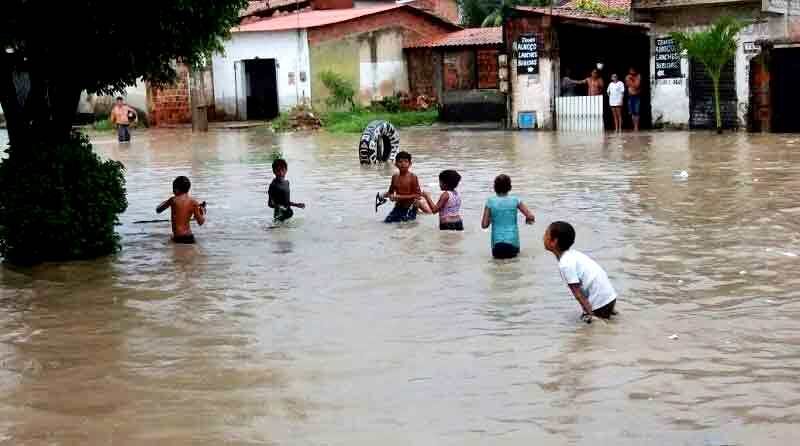 Crianças brincando em água durante enchente.
