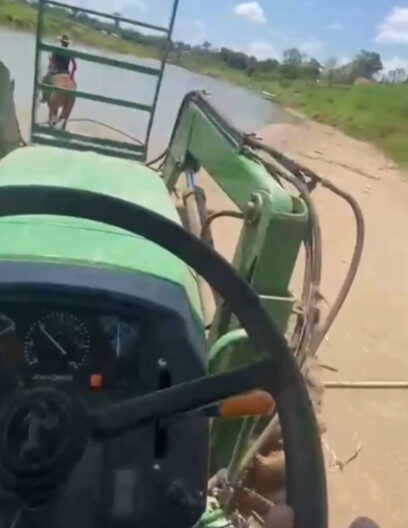 Caseiro de fazenda atravessa rio de trator durante estiagem intensa no Acre