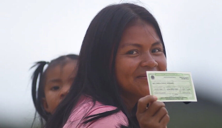 Indígena do Amazonas segurando o documento de título de eleitor